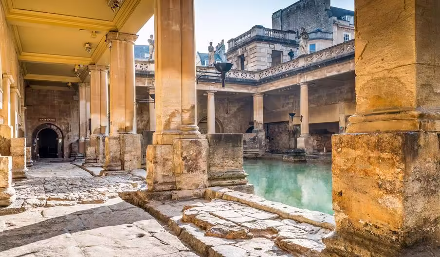 Roman Baths Roman Baths in Bath, UK, during the day, with sunlight reflecting off the water